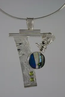 Silver artistic necklace with glass and stone accents.