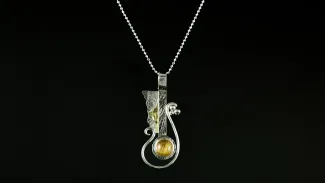 Pendant with silver, gold, and yellow stone