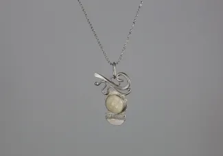 Silver pendant with carved ivory moon face