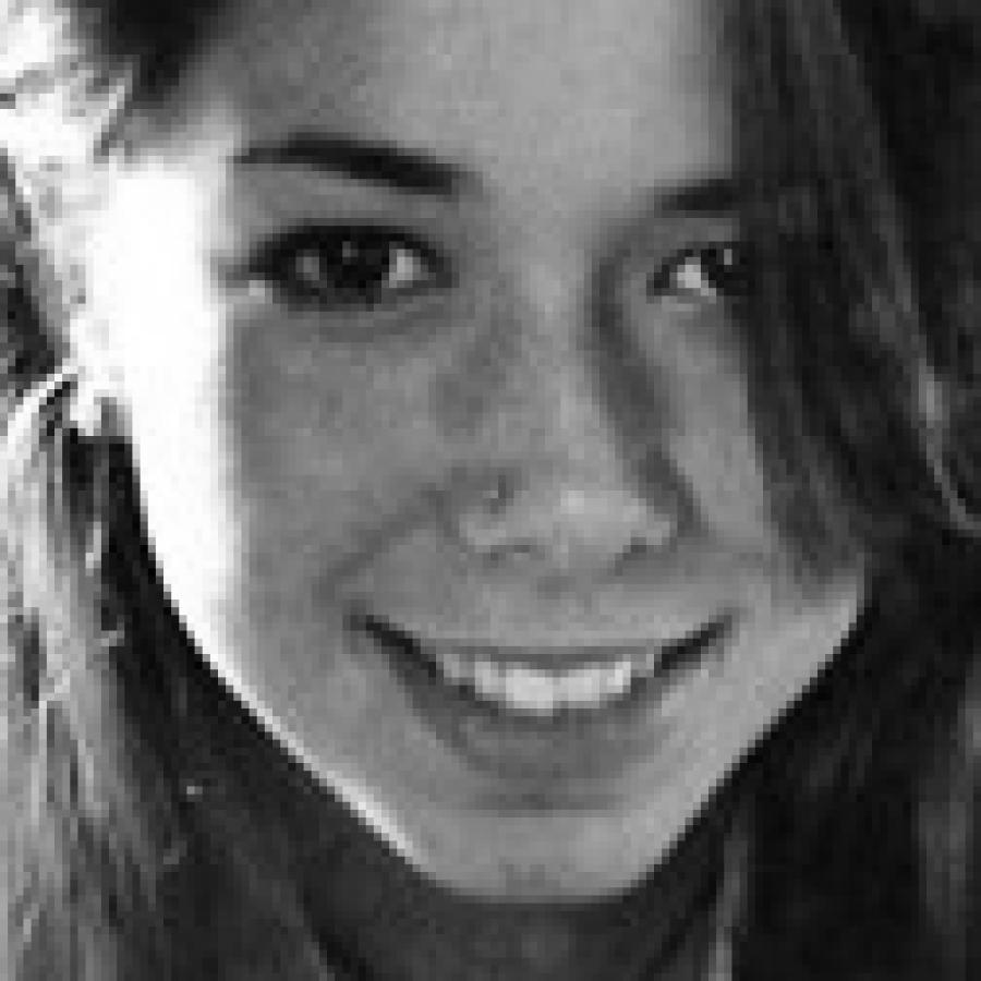 Close-up photograph of a smiling young woman with dark hair.