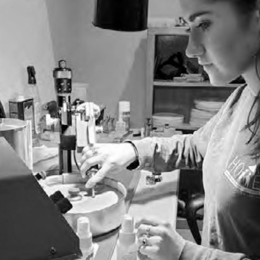 Photograph of a woman using a rotary tool in a workshop.