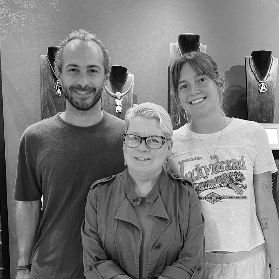 Photograph of three people posing in a jewelry store.