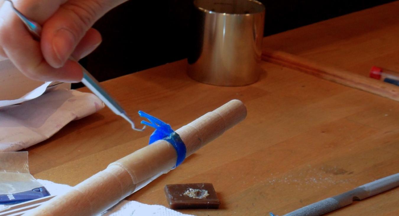 Forming a wax ring with a dental tool.