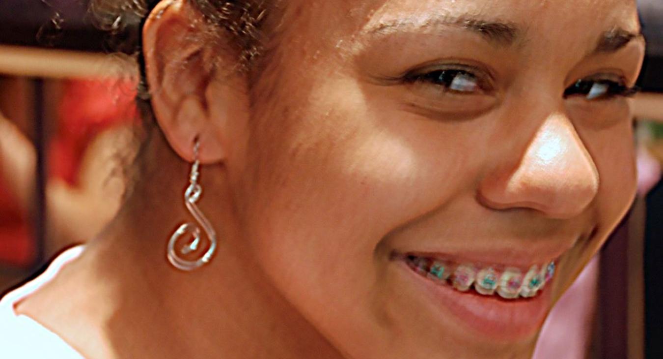 A smiling girl with silver earrings
