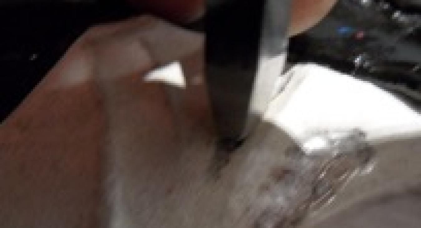 A close-up photograph of a depressing a piece of metal.