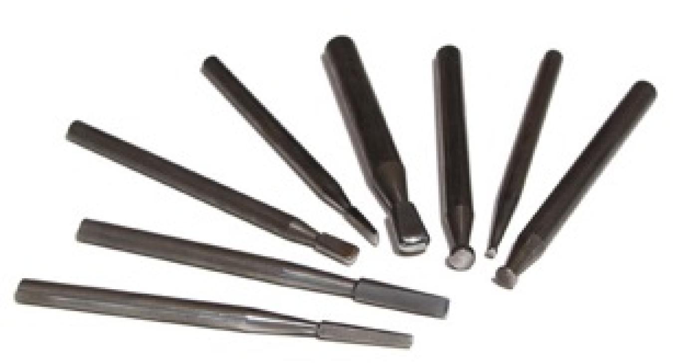 Photograph of a set of black steel punches on a white background.