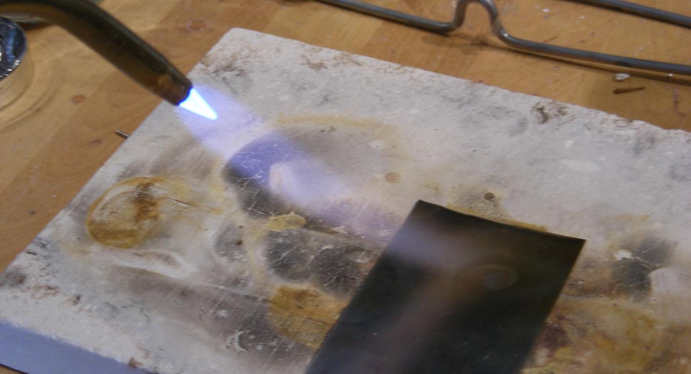 An acetylene torch pointed at sterling silver.