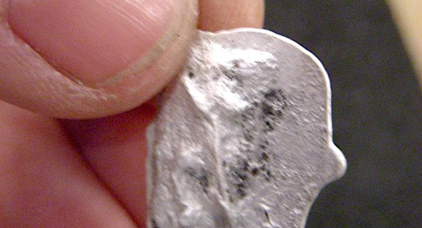 Silver, charcoal-cast link.