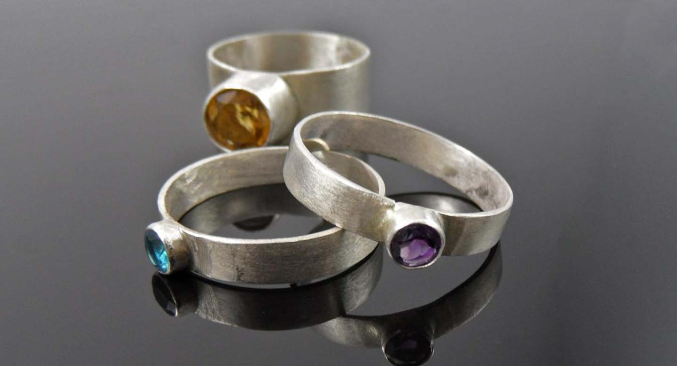 Facetted ring set by Roxana Fugleberg with amethyst, quartz, and topaz.