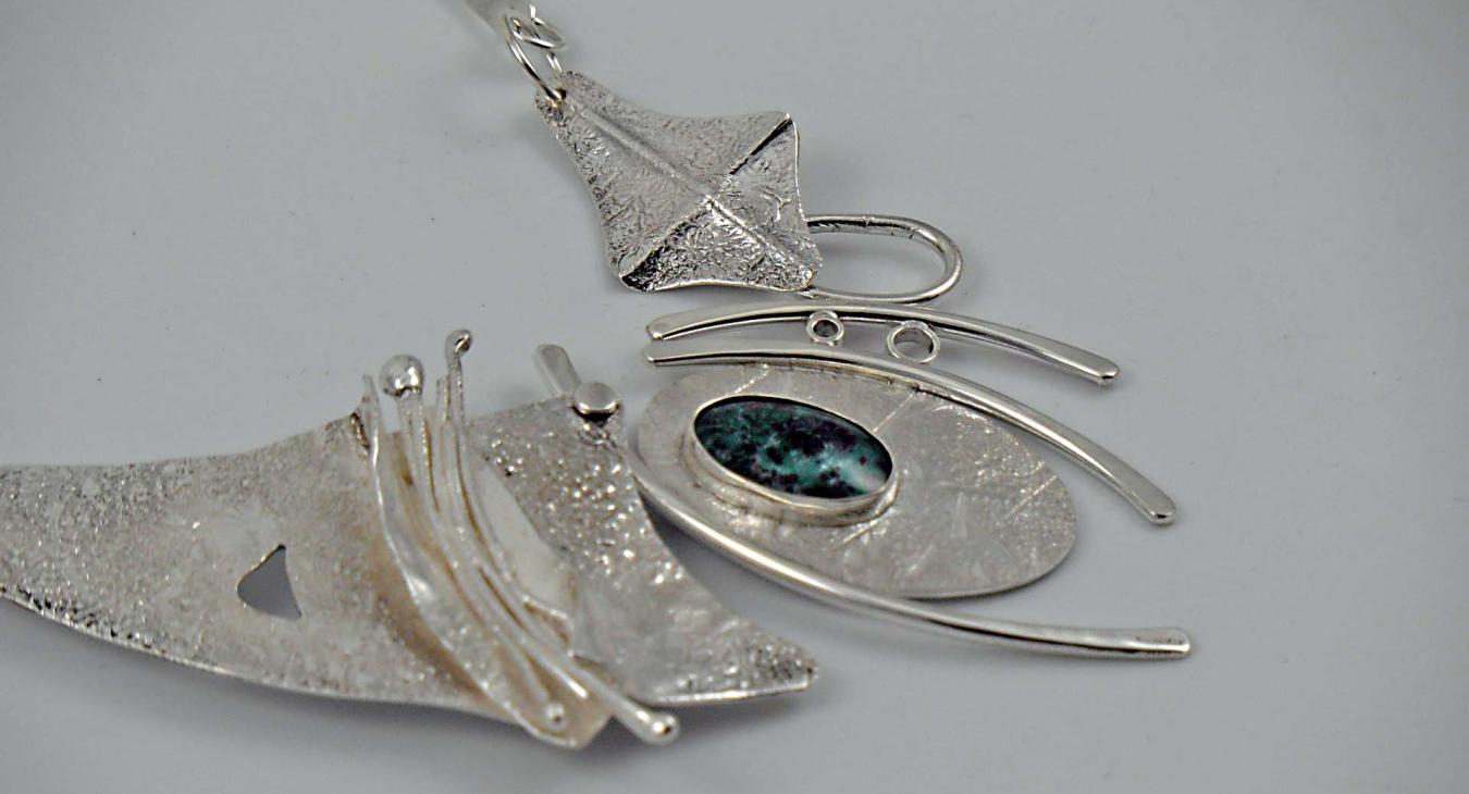 Textured silver necklace piece, with dark blue-green stone