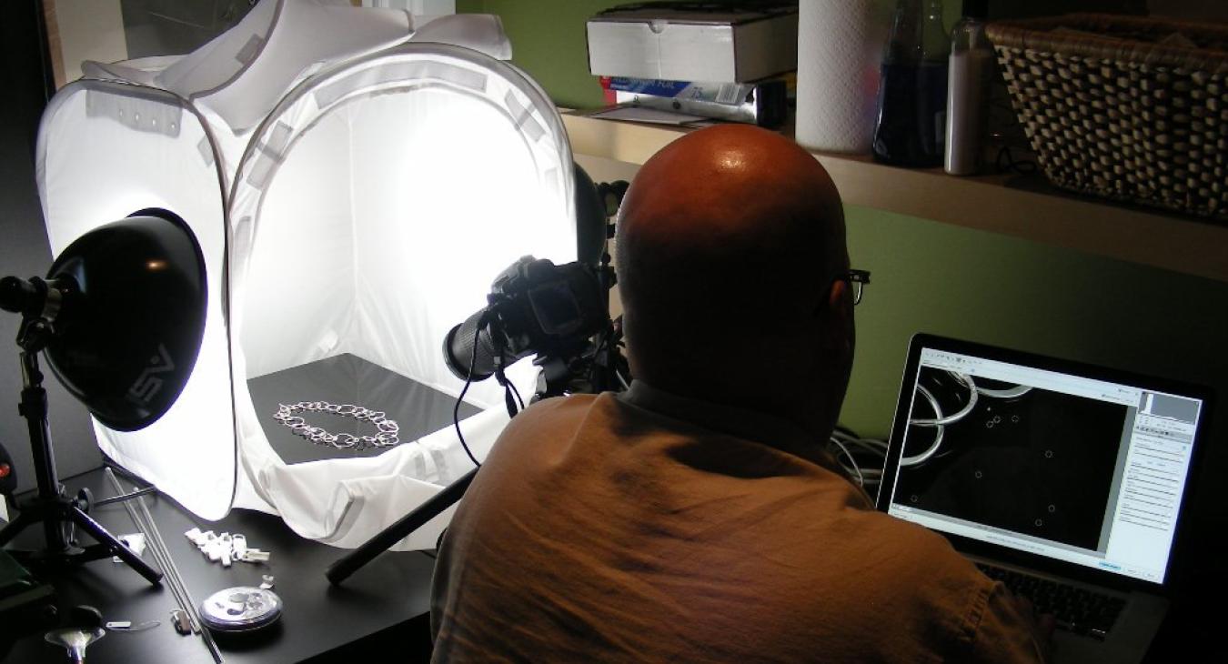 Bryan with computer and lightbox for photographing the jewelry
