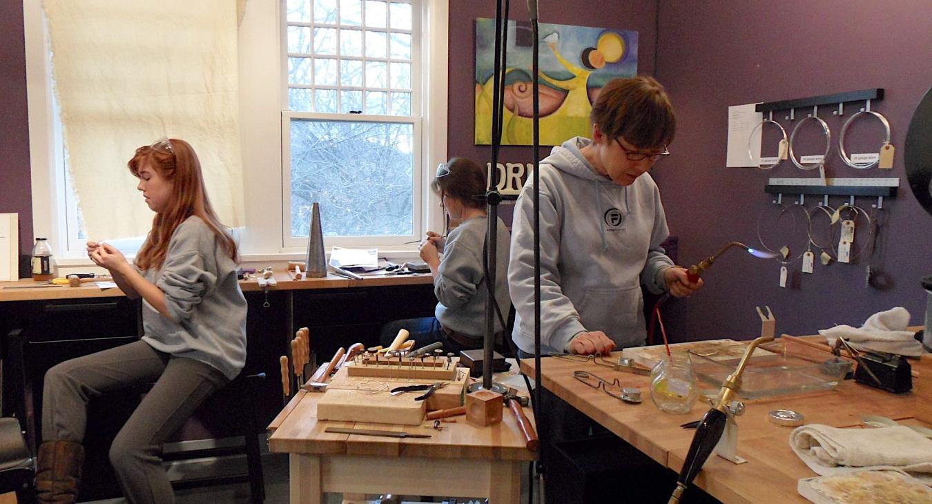 Beth and daughters working on their projects at soldering station and bench