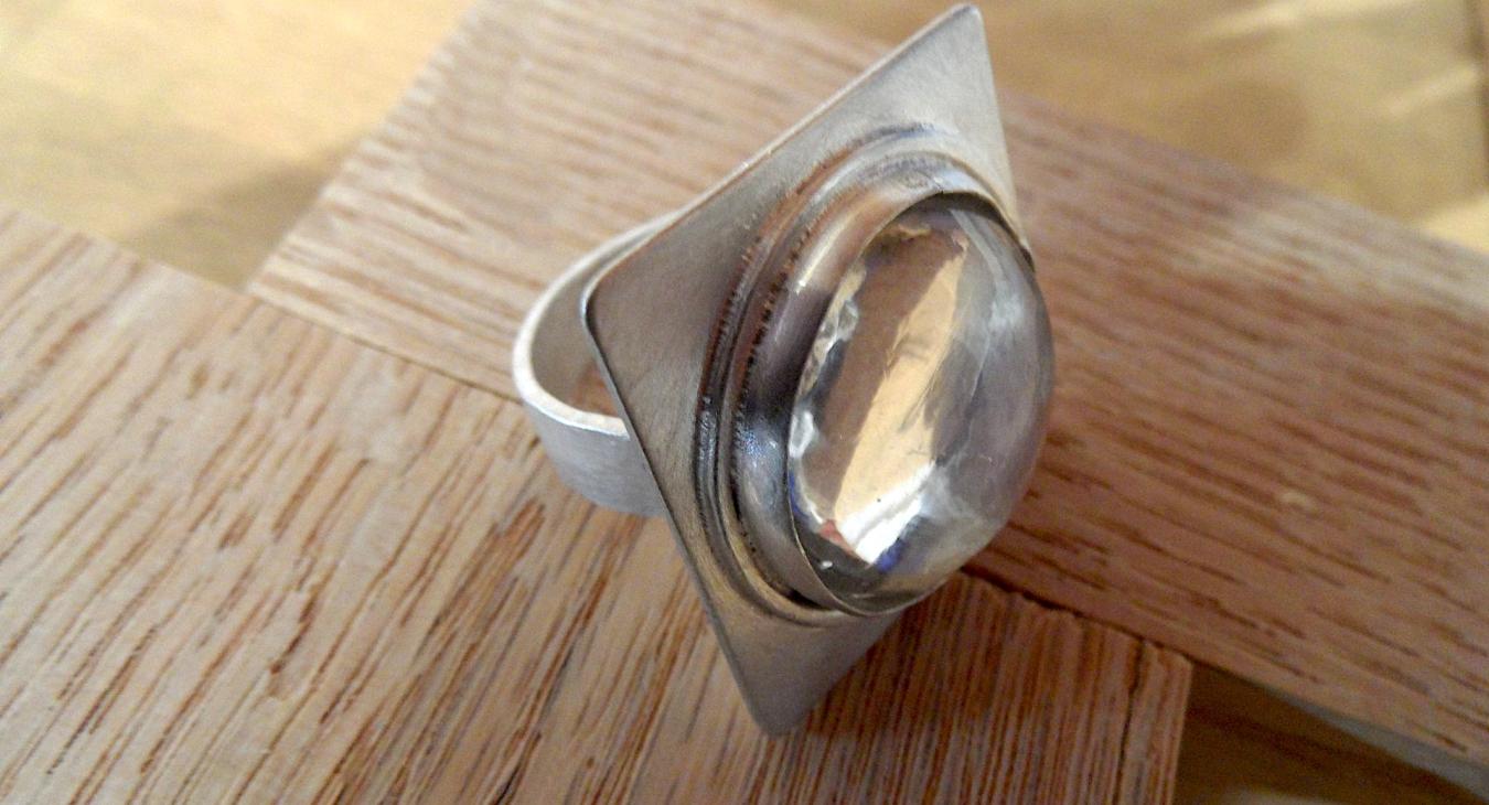 Silver ring with clear stone set on square face