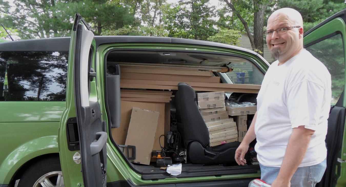 Bryan standing next to car packed with materials