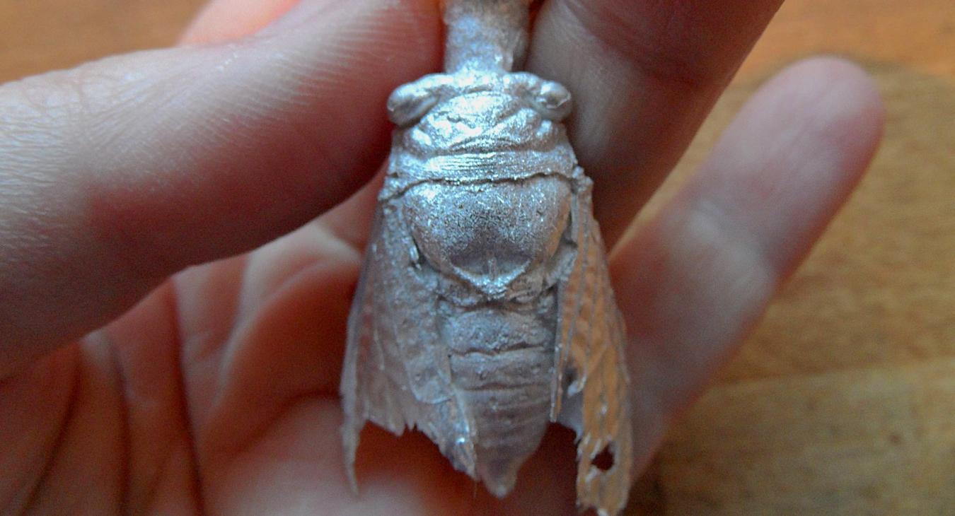 A silver cast of a Cicada