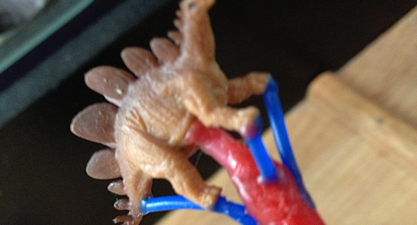 A little plastic dinosaur on a sprue for casting.
