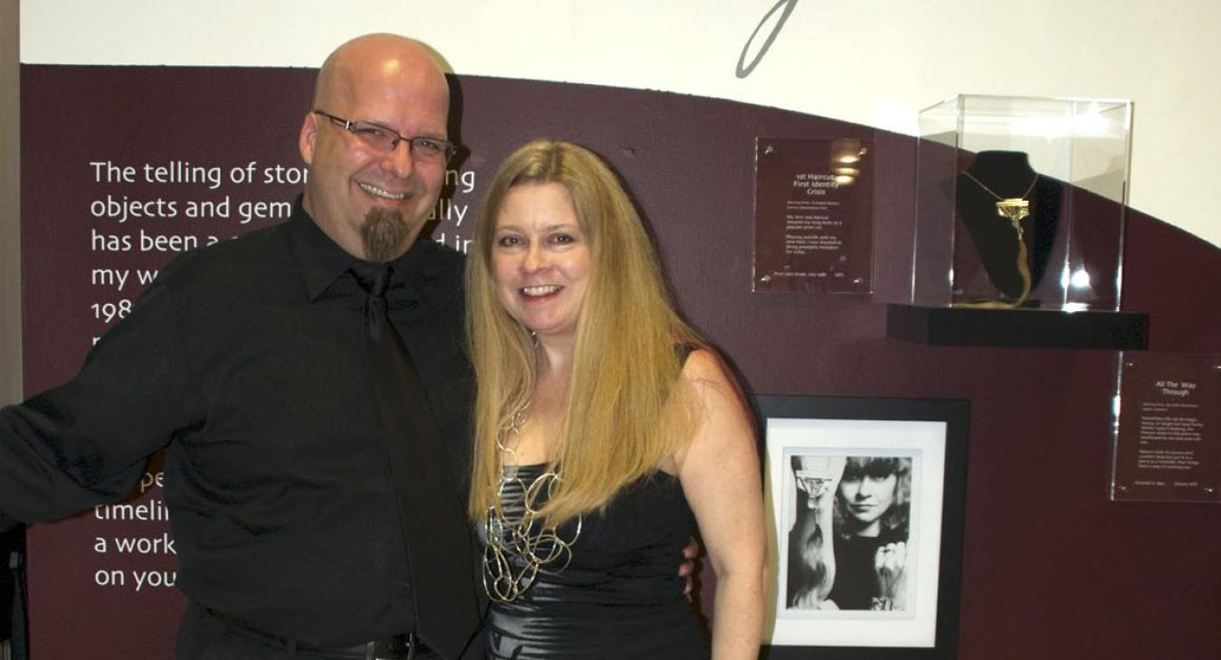 Blair and husband Bryan in front of the title wall