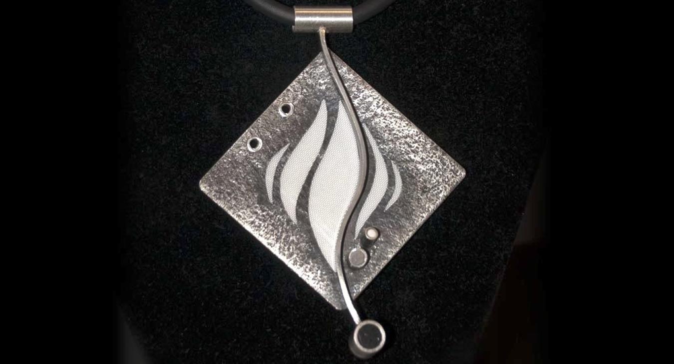 Textured diamond shaped silver pendant with white flames