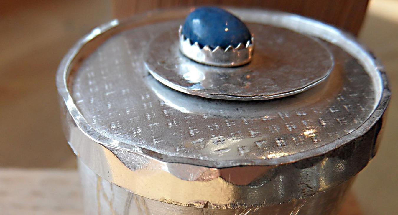 Textured silver box with blue stone set on top 