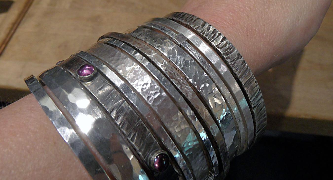 Heavy silver bangles on wrist