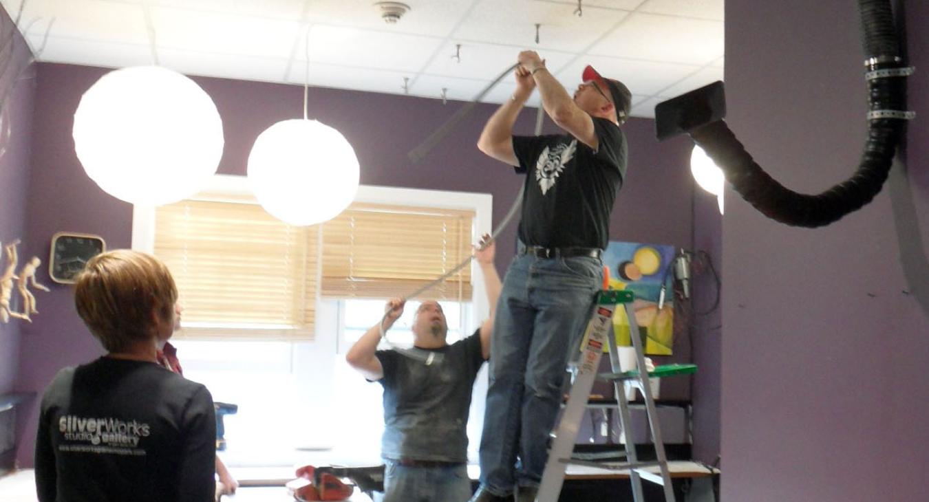 Neil on ladder installing new studio lights