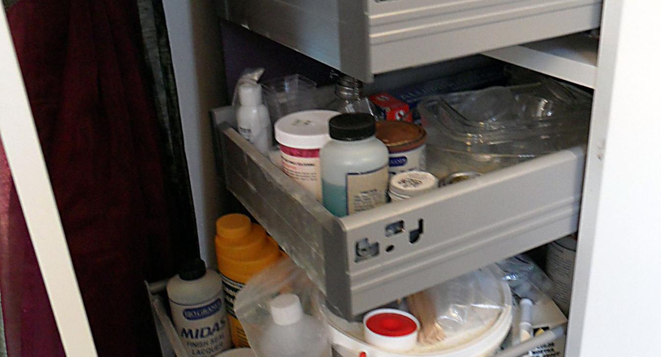 chemical cabinet open filled with different bottles in drawers