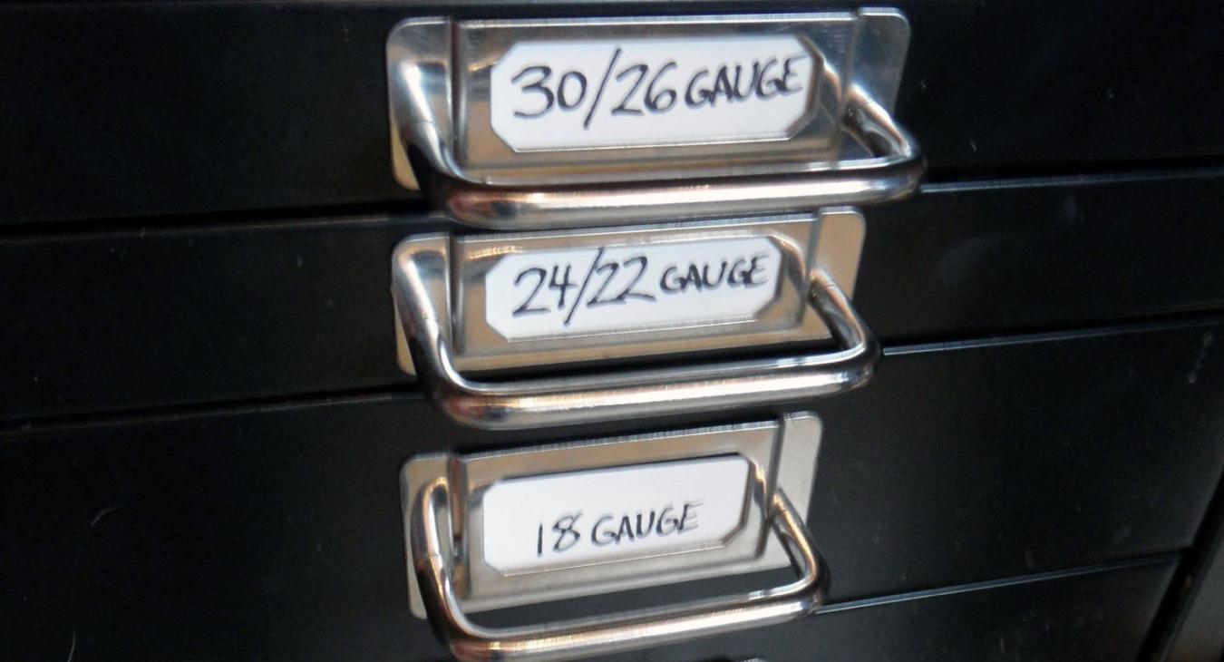 black drawers with metal handles labeled with different gauges