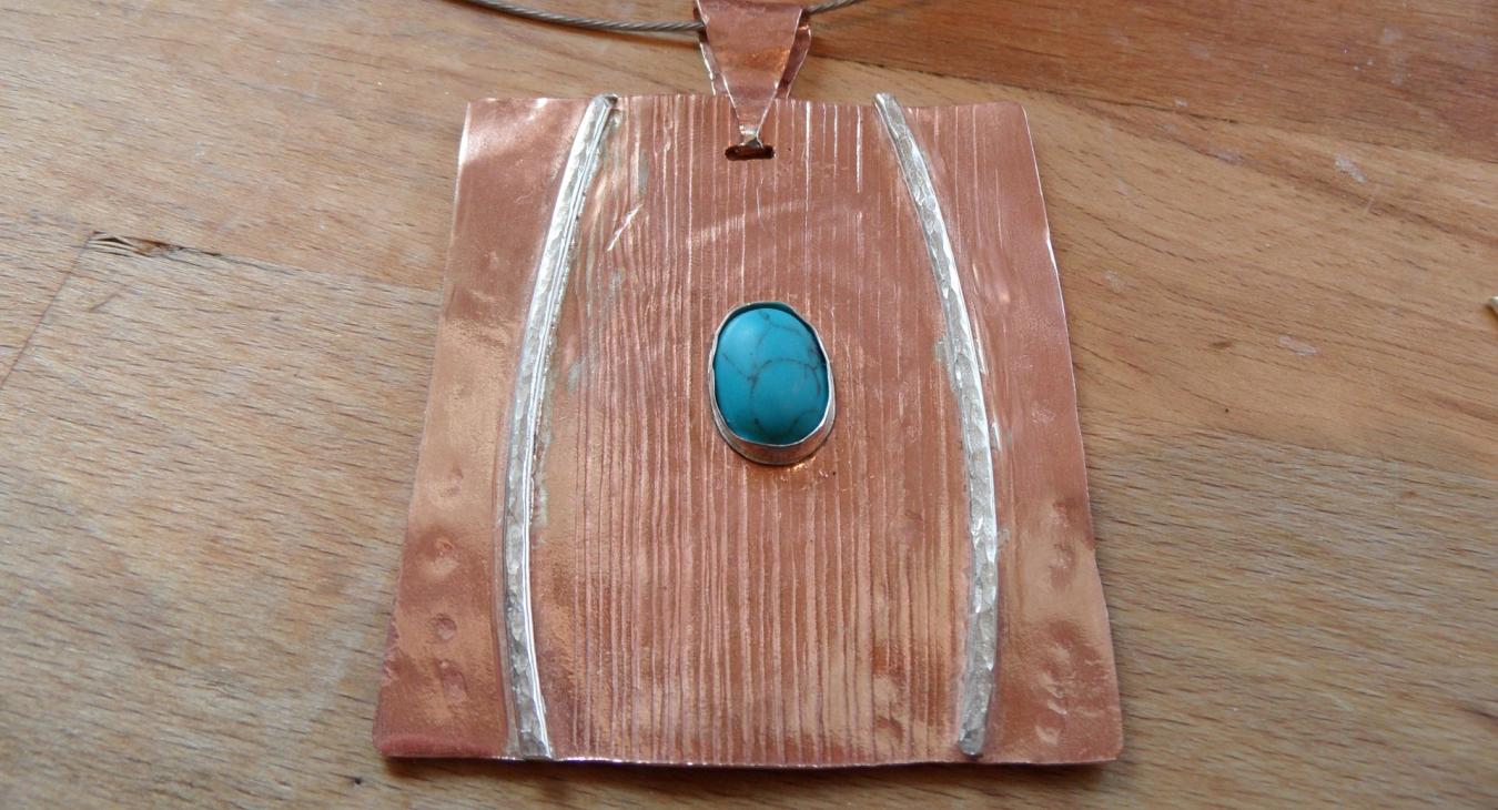textured copper pendant with silver wire and turquoise stone