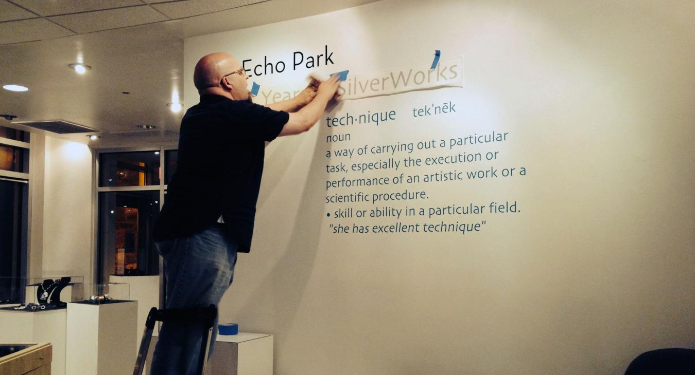 Bryan on step stool putting up vinyl text