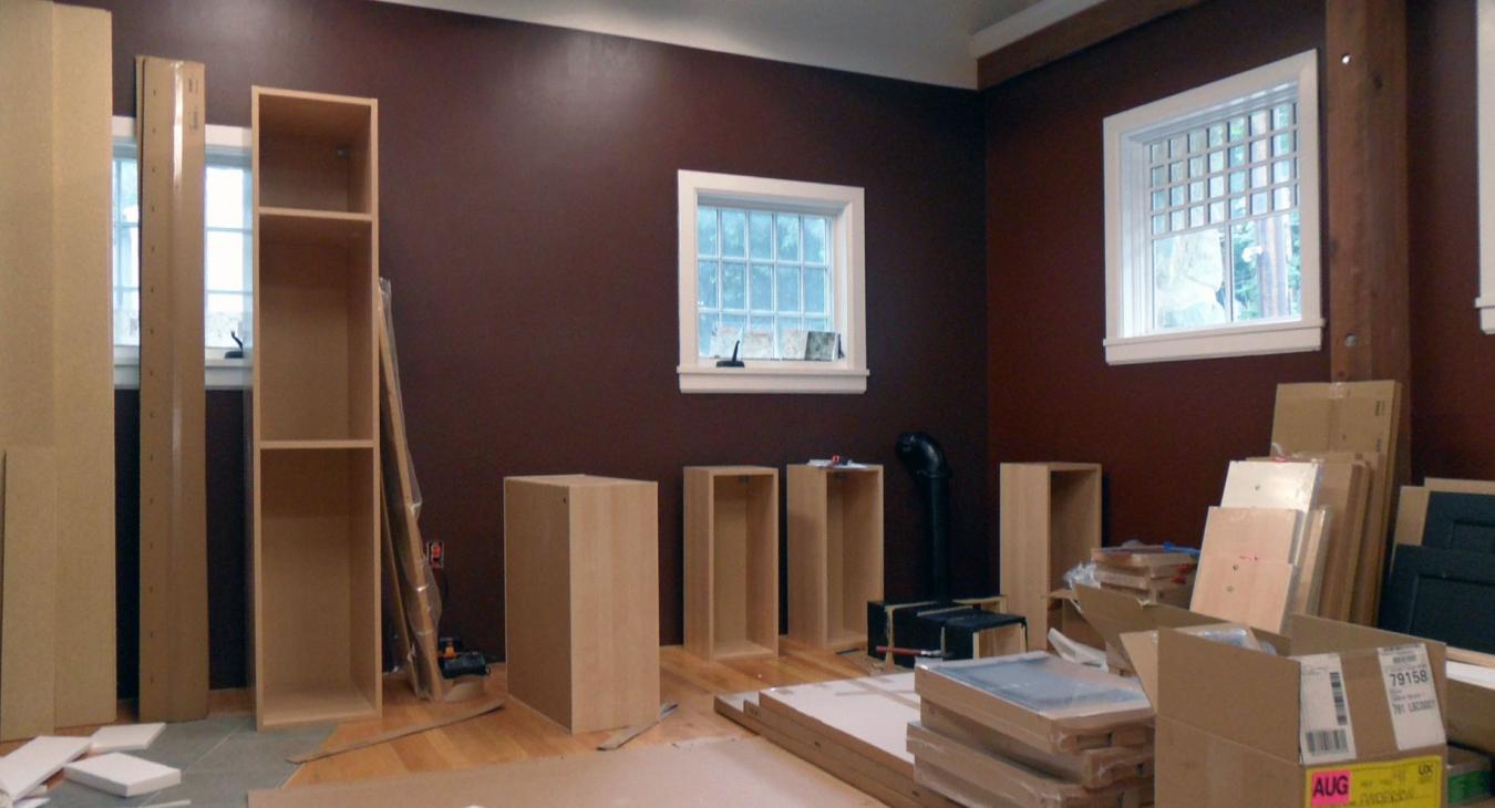 brown painted studio 2 under construction, with scattered wood planks and cabinets