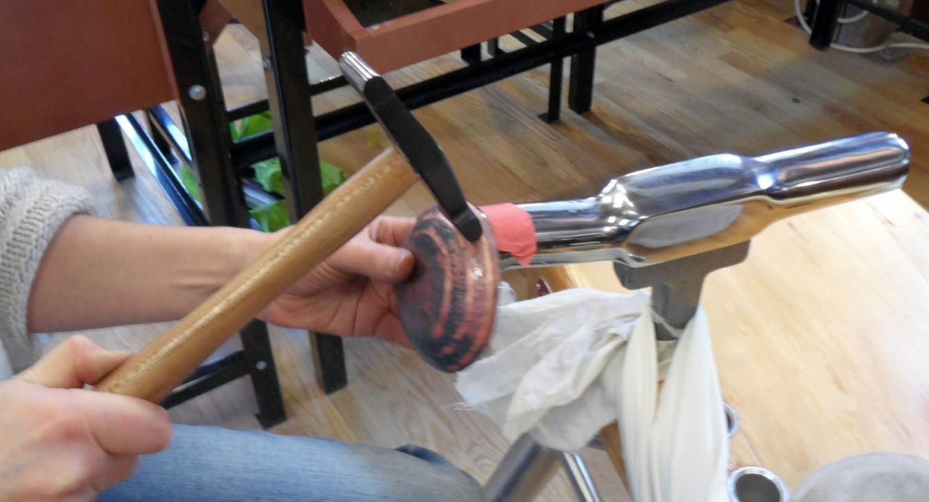 Hammering copper on steel stake
