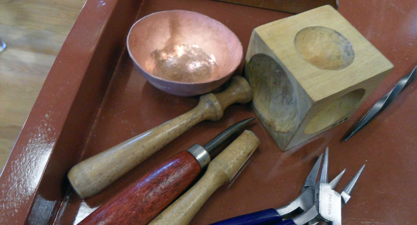 copper bowl and tools used for raising including dapping tools and pliers