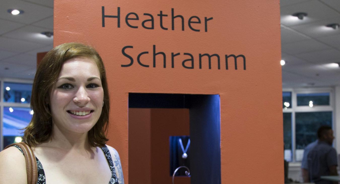Heather standing by her tower display with name and work