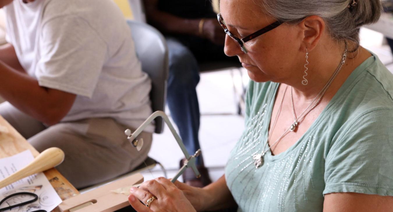 student sawing at bench pin