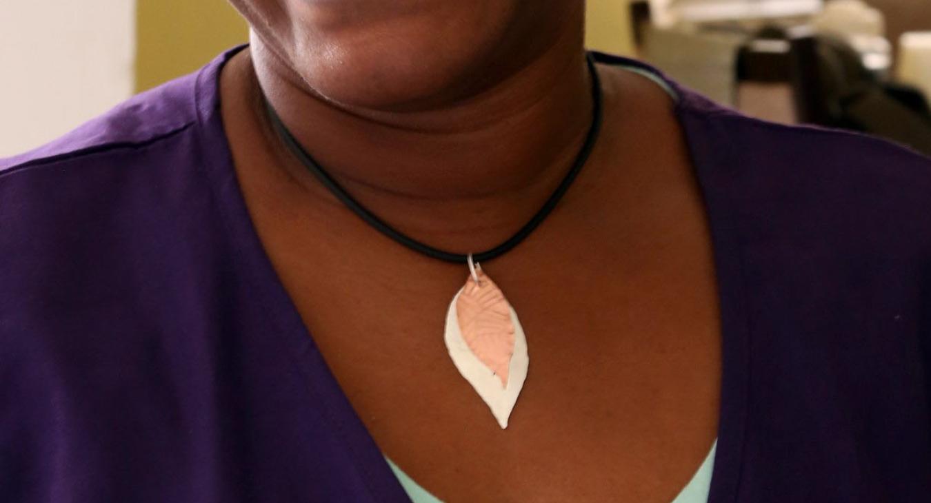 Phelice Jones smiling wearing the leaf pendant she made