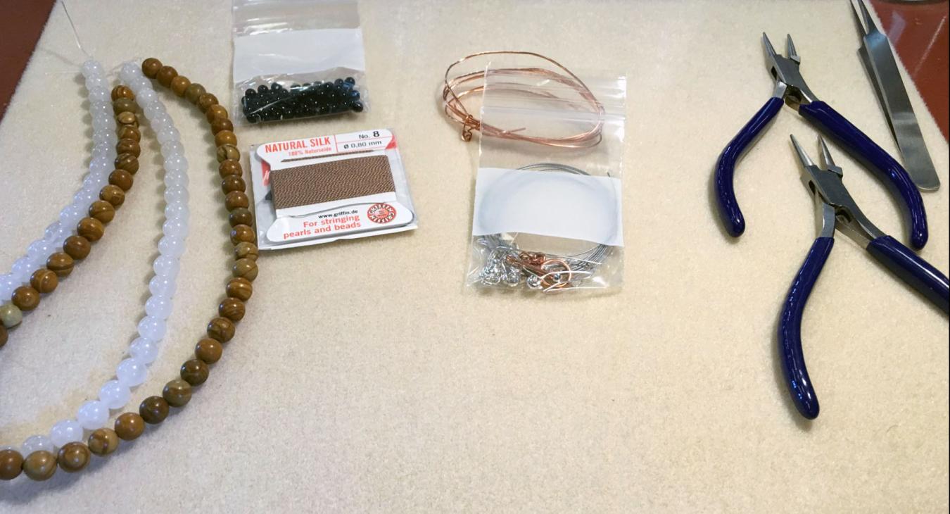 tools laid out for workshop, beads string and pliers. 