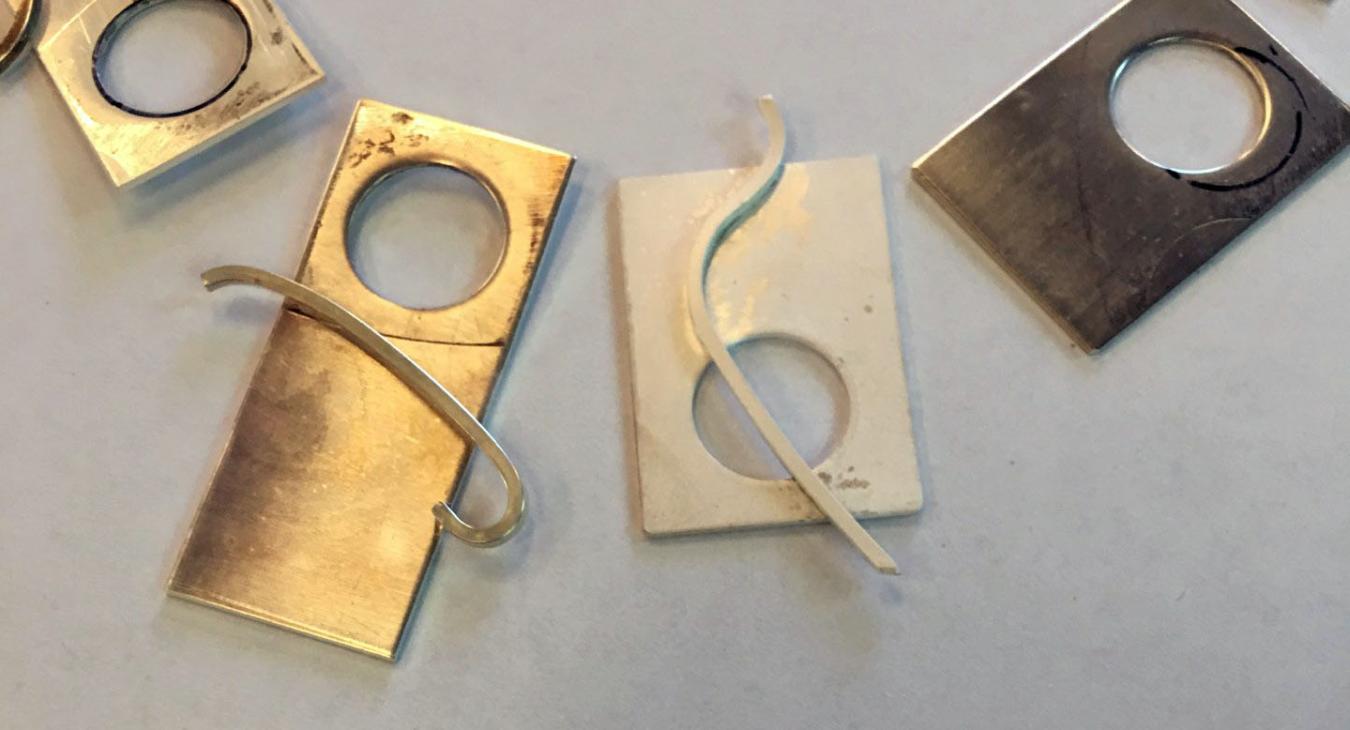 silver rectangles with disc cutout arrayed on paper