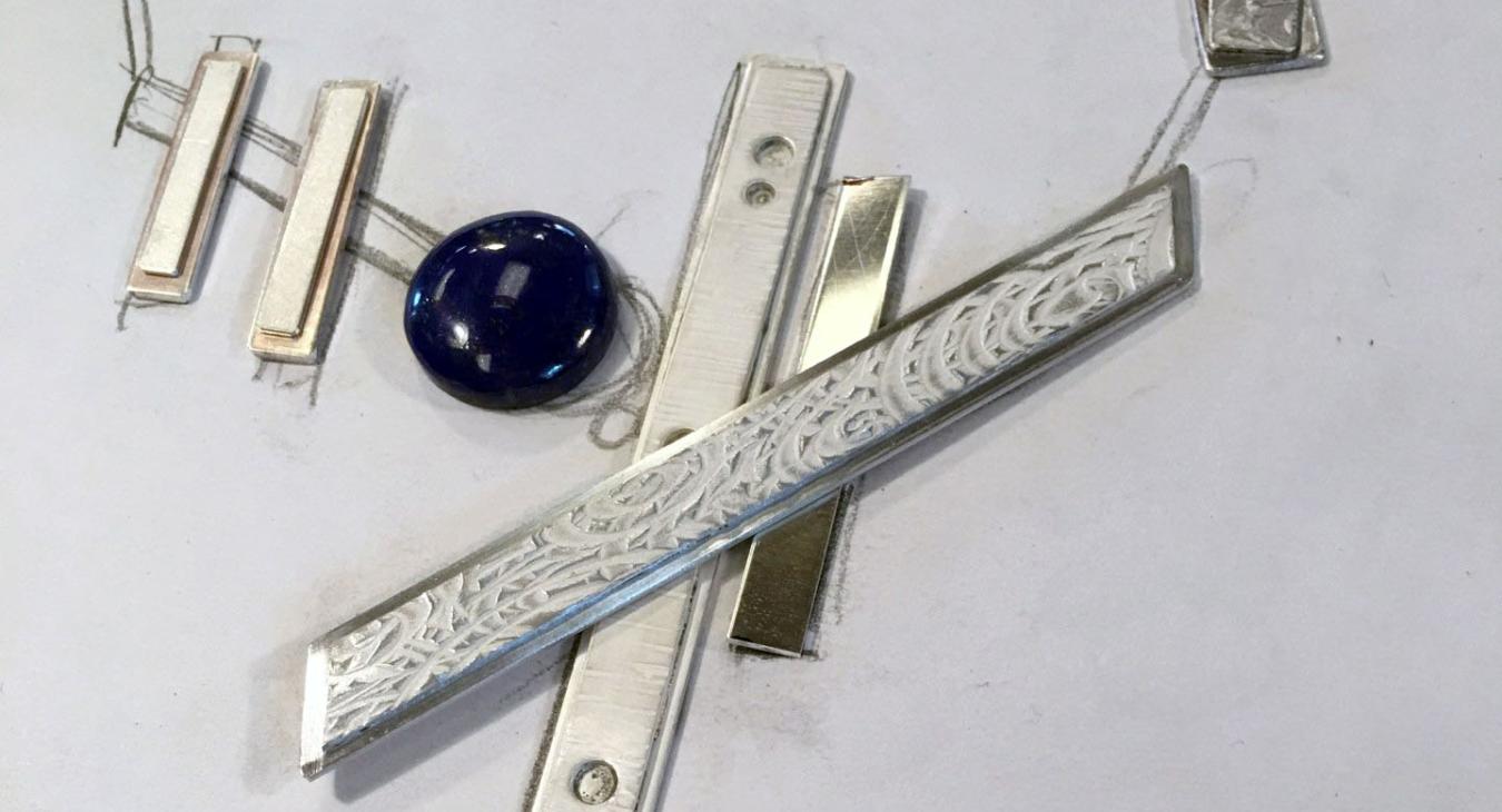 Pendant laid out on paper with blue stone
