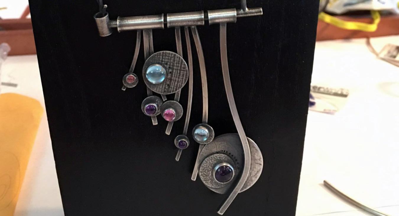finished mounted piece - hanging strands of silver wire and blue and pink stones set on discs