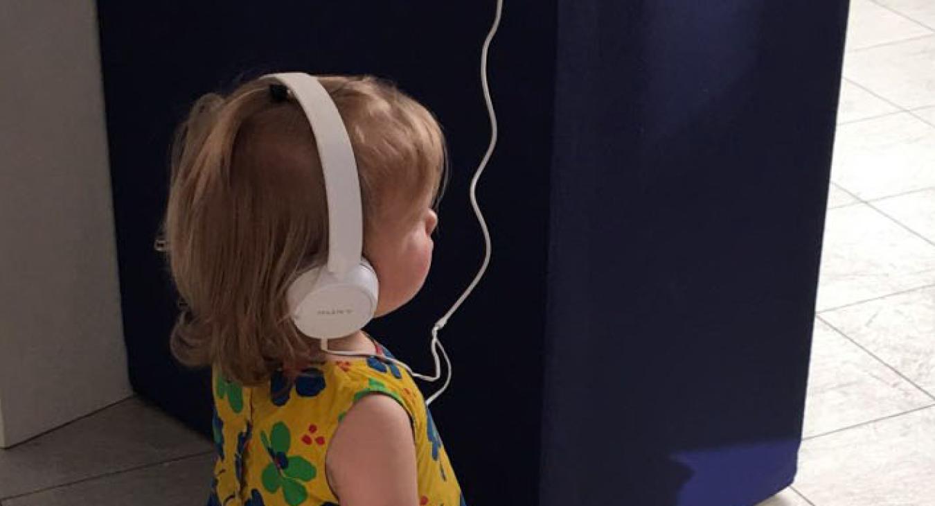small child listening to tower display headphones