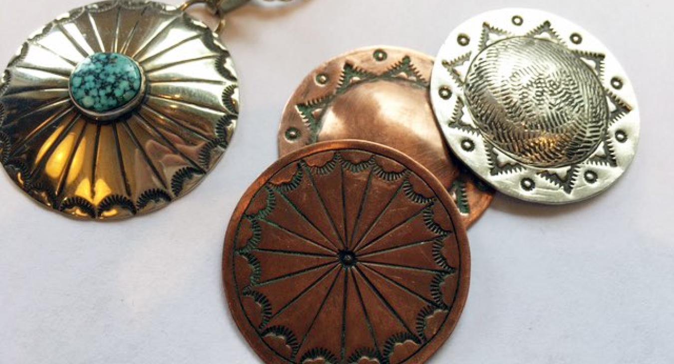 circular stamped pendants in various metals, one with turquoise in center