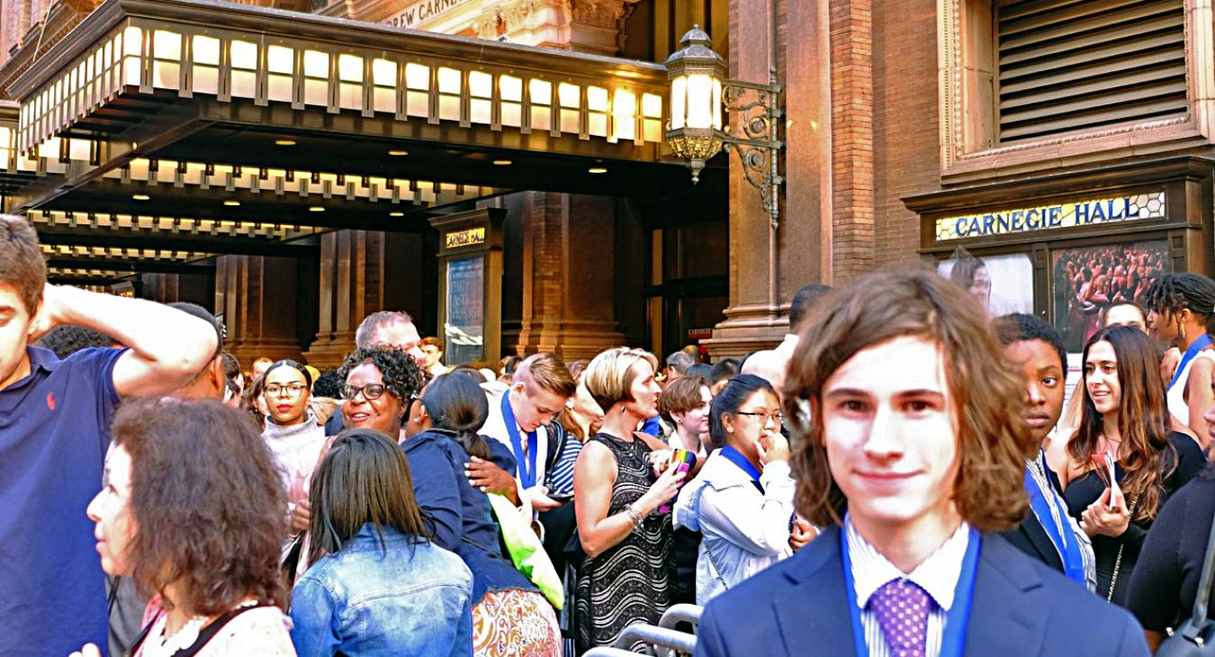 Louis in a suit in front of Carnegie Hall