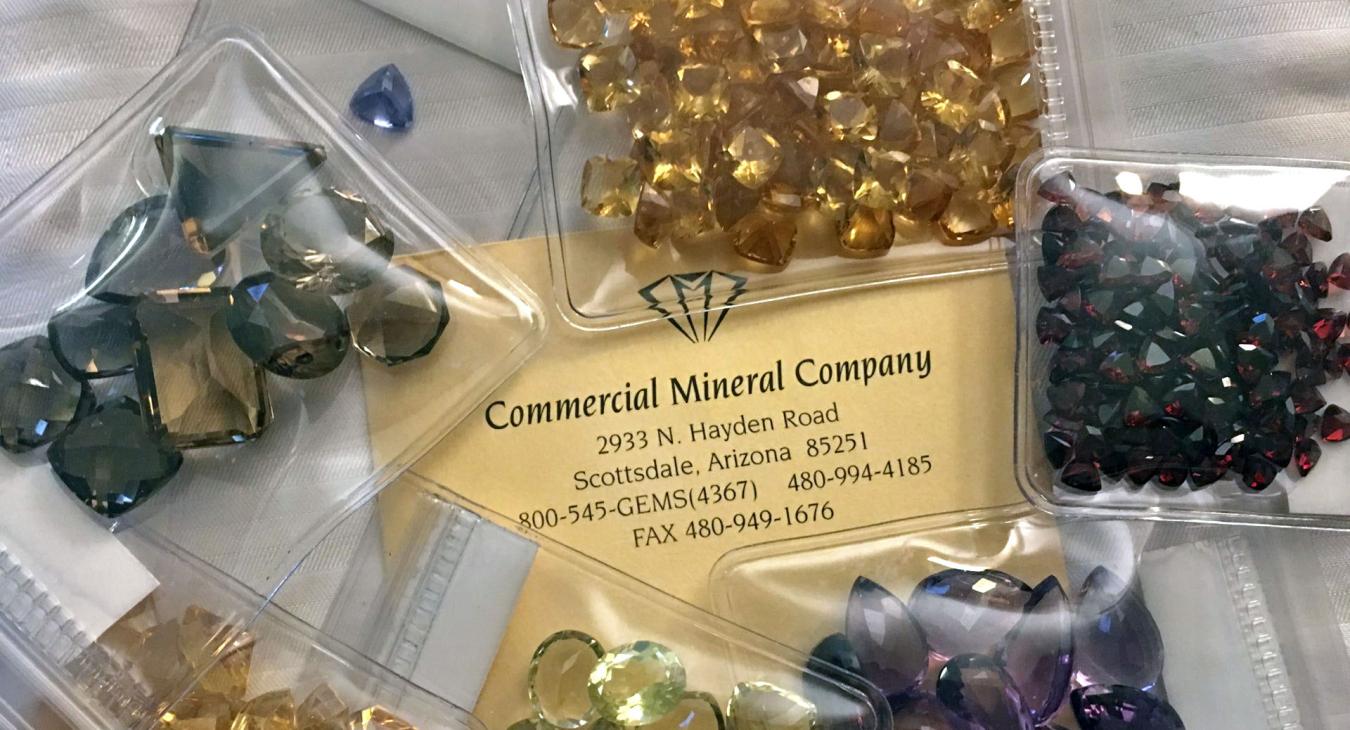 transculescent yellow purple and green stones in packets around company card