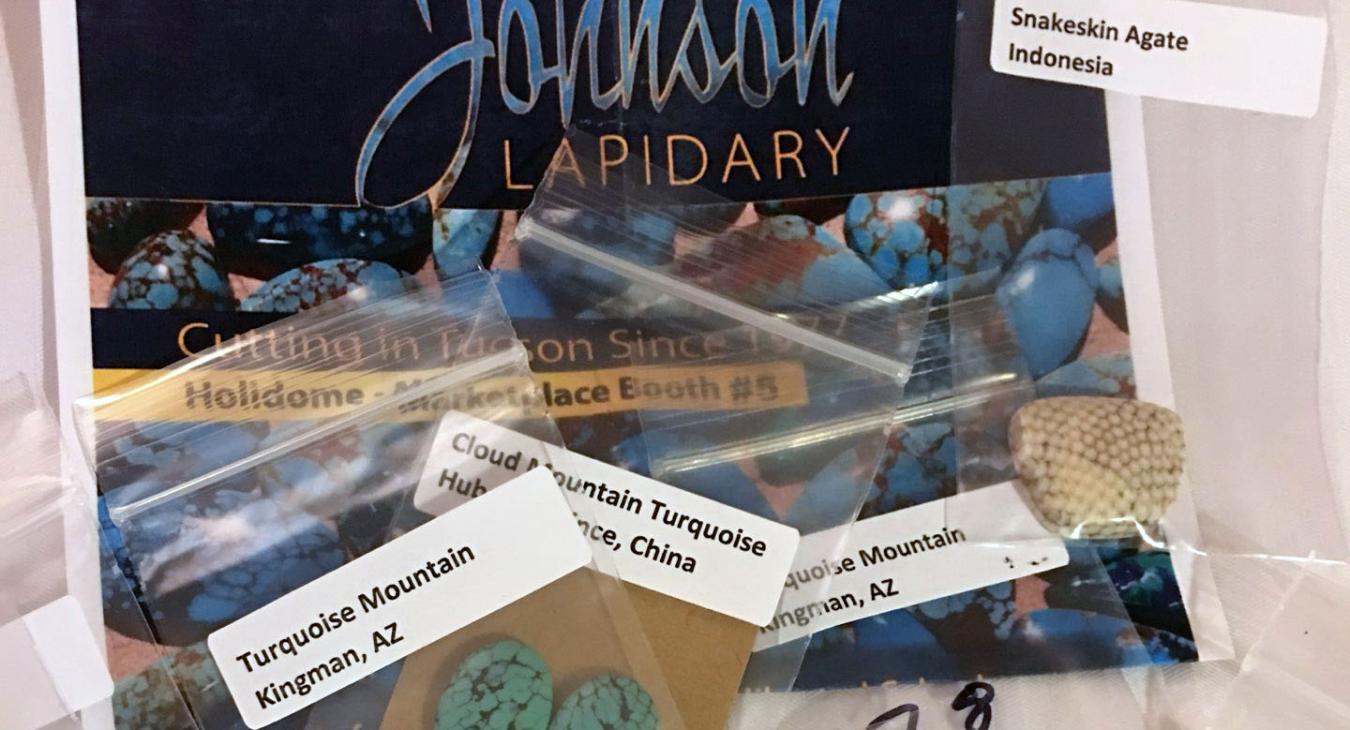 variety of turquoise and agate in packets next to company card