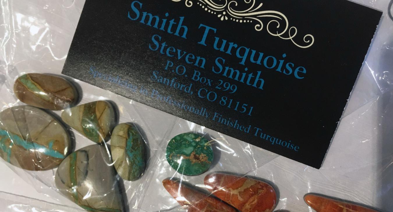 green-brown and red-orange stones next to company card