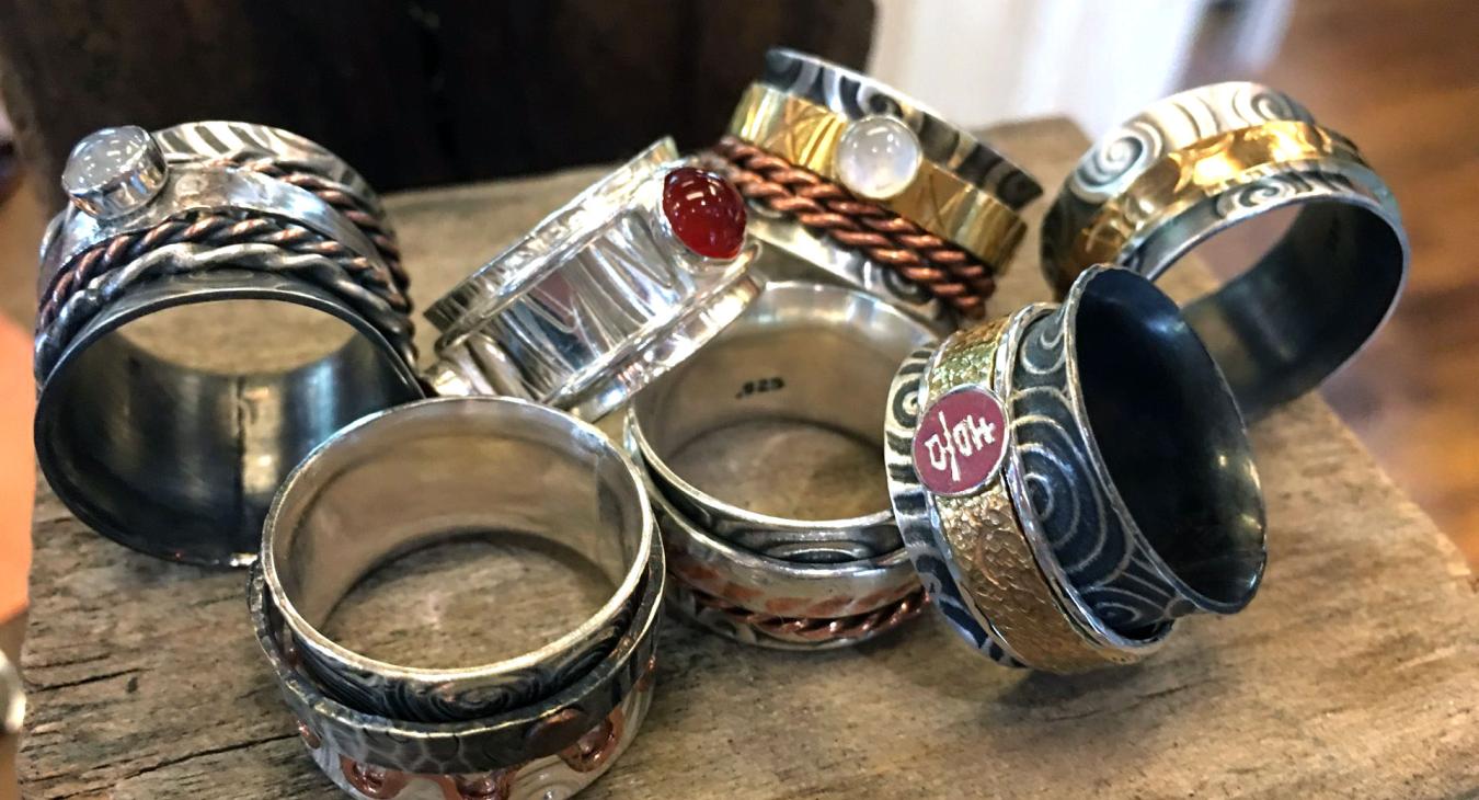 a pile of spinner rings with various bands and stones