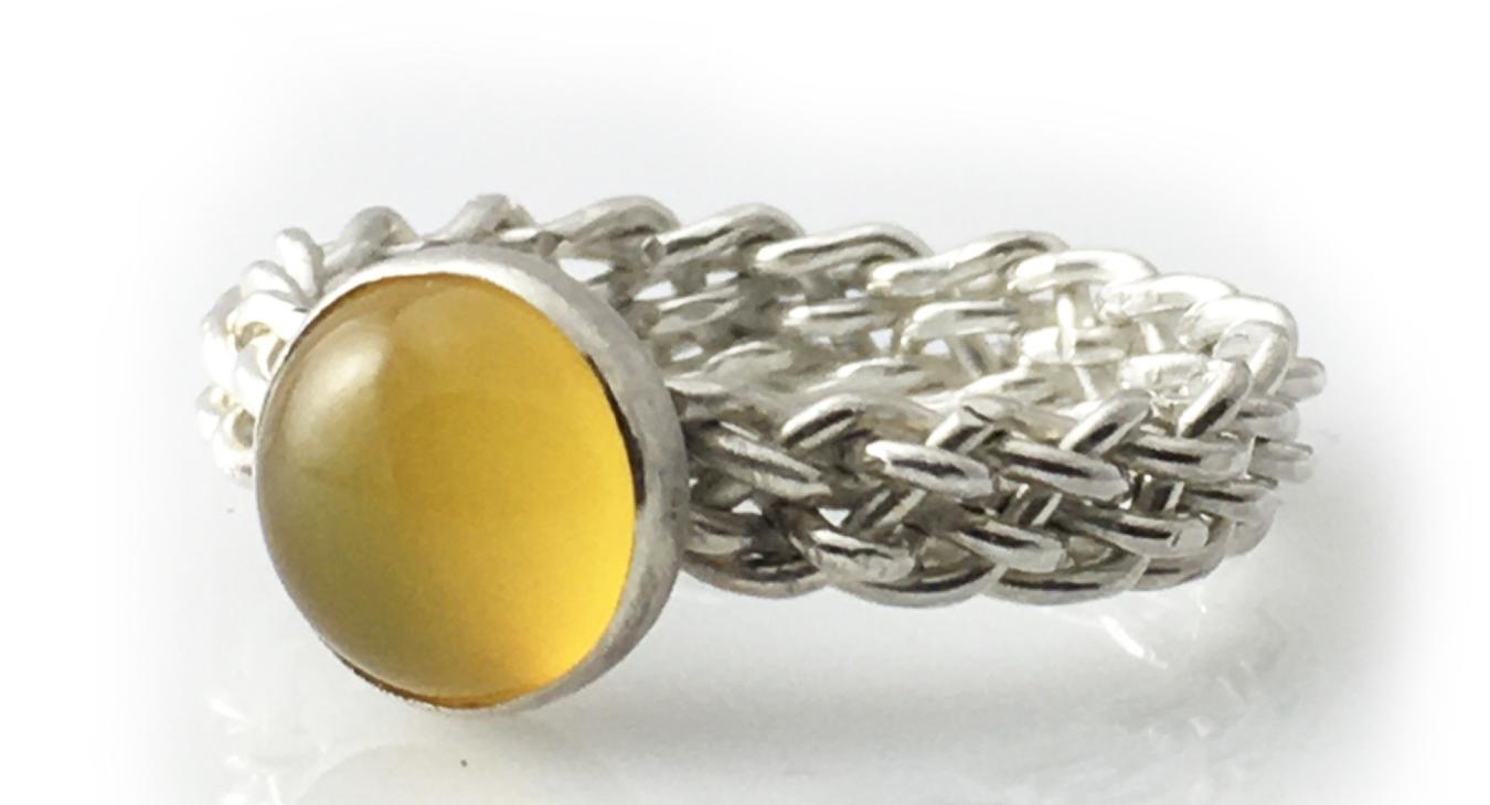 A wire woven ring with a yellow stone