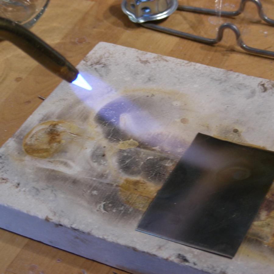 An acetylene torch pointed at sterling silver.