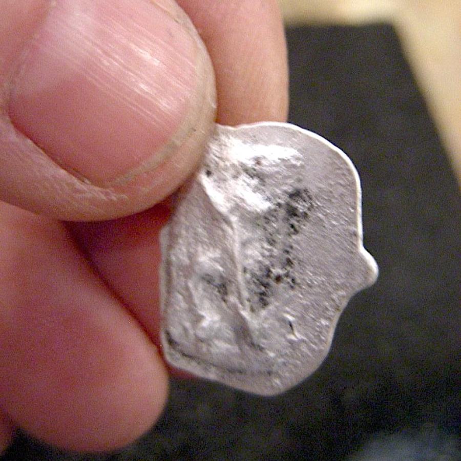 Silver, charcoal-cast link.