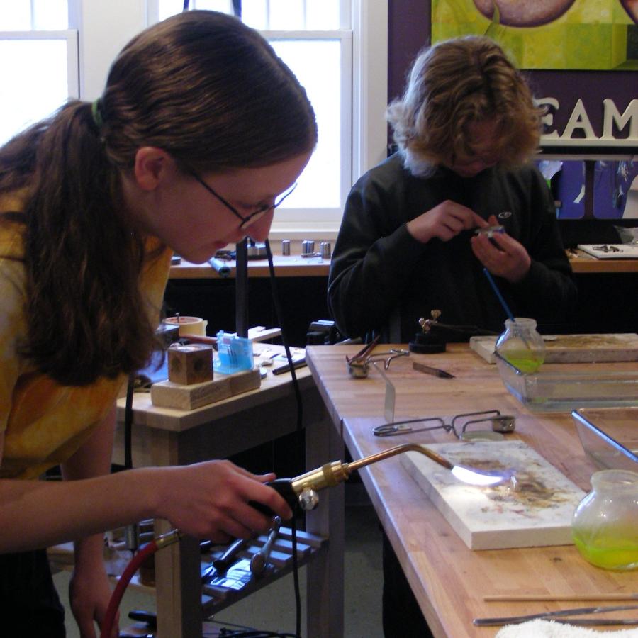 Maura with the torch in front of soldering station